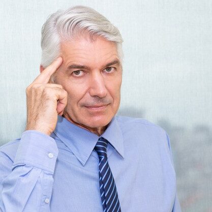 portrait-of-serious-businessman-pointing-at-head_1262-2397
